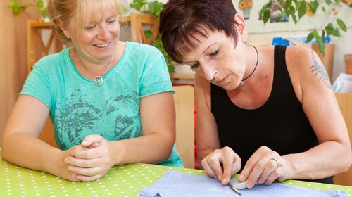 Zwei Frauen sitzen konzentriert am Tisch Zwei Frauen am Tisch
