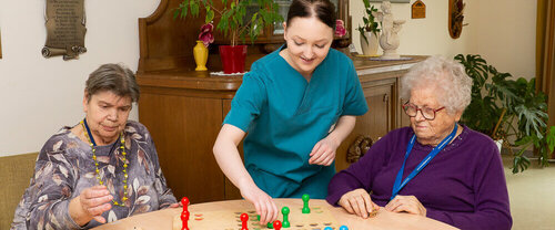 Freiwilligendienst im Pommerschen Diakonieverein Eine junge Frau spielt mit zwei älteren Frauen Mensch Ärgere Dich nicht