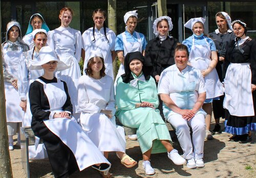 Eine Gruppe von Frauen trägt Pflegekleidung, wie sie in früheren Zeiten getragen wurde