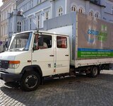 Ein LKW mit Aufschrift Ostseeländer Biowelt steht vor Gebäuden auf dem Greifswalder Marktplatz