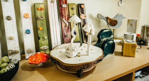 Holzprodukte aus der Werkstatt für behinderte Menschen Kunstvolle Holzpilze stehen auf einem ausgesägten Baumstamm