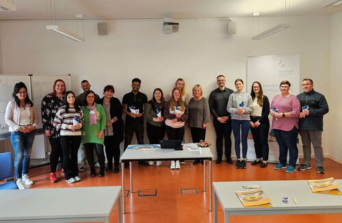 Pflege-Auszubildende und Dozenten stehen als Gruppe bei der Einführung in das Ausbildungsjahr zusammen