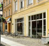 Außenansicht des Café und Restaurant Lichtblick vom Greifswalder Rathaus aus mit Aufsteller Mittagstisch und Blumenschmuck