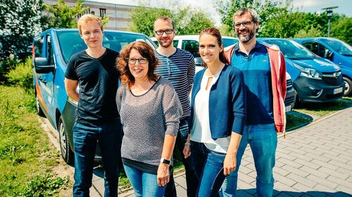 Weiterbildung und Umschulung in der WA Nord Eine Gruppe von Menschen steht zusammen vor Autos