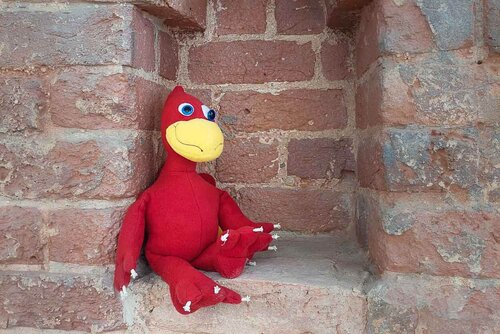 Ein Kuscheltier sitzt in einer Backsteinmauerlücke