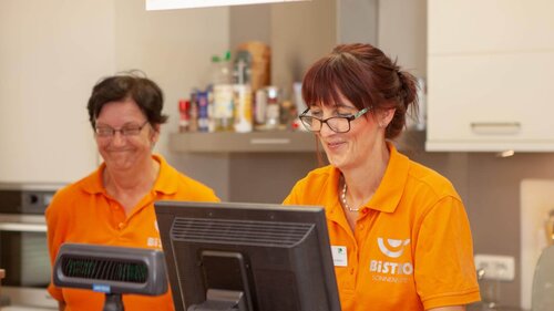 Mitarbeitende bedienen eine Kasse Damen an der Kasse