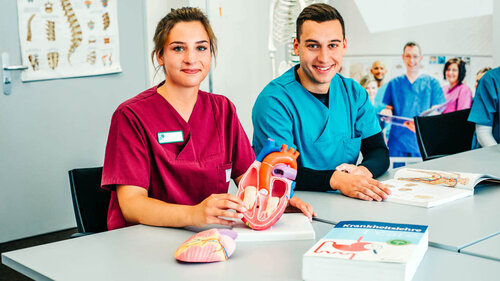 Ausbildung und Berufsorientierung Eine junge Frau und ein junger Mann sitzen in Dienstkleidung in der Ausbildungssituation