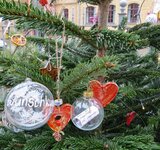 Ein Weihnachtsbaum mit vielen Kugeln und Wunschzetteln geschmückt