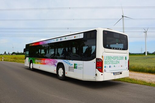 Der Bus von hinten betrachtet mit den Logos und Motto der Unternehmensgruppe Pommersche Diakonie