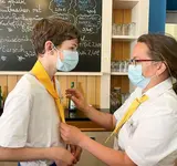 Eine Frau bindet einem Jungen einen Schlips