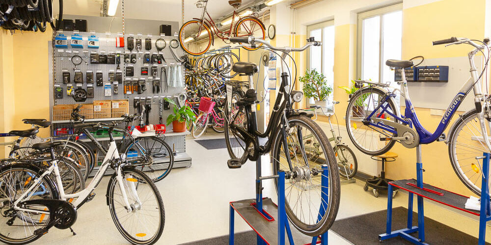 Blick in die Fahrradwerkstatt mit verschiedenen Rädern, die zur Reparatur aufgestellt sind
