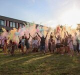 Begeisterung im Farbnebel Eine große jubelnde Menge steht in einem Nebel aus Farben