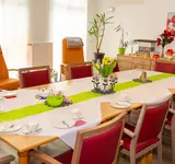 Ein großer gedeckter Tisch mit Stühlen in der Tagespflege Demmin