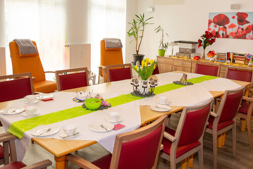 Ein großer gedeckter Tisch mit Stühlen in der Tagespflege Demmin
